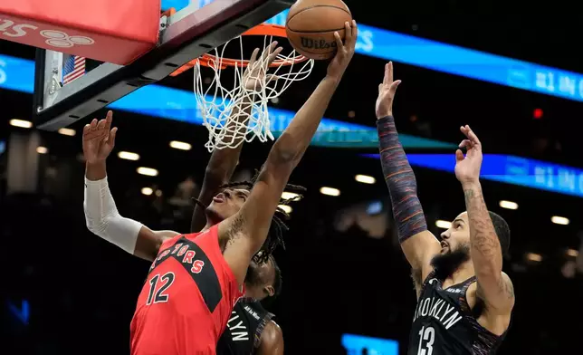 Toronto Raptors forward Collin Murray-Boyles (12) shoots during the first half of an NBA basketball game against the Brooklyn Nets, Sunday, Dec. 21, 2025, in New York. (AP Photo/Yuki Iwamura)