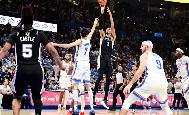 San Antonio Spurs Victor Wembanyama (1) shoots against Oklahoma City Thunder center/forward Chet Holmgren (7) during the first half of an NBA basketball game, Thursday, Dec. 25, 2025, in Oklahoma City. (AP Photo/Gerald Leong)