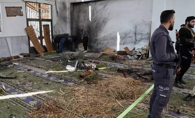 Syrian security forces inspect the damage after an explosion in the Imam Ali bin Abi Talib Mosque in a predominantly Alawite area of the Wadi al-Dhahab neighborhood in Homs, Syria Friday, Dec. 26, 2025.(AP Photo)