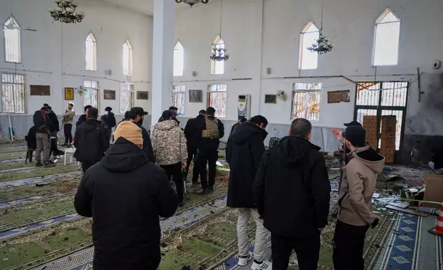 Syrian security forces inspect the damage after an explosion in the Imam Ali bin Abi Talib Mosque in a predominantly Alawite area of the Wadi al-Dhahab neighborhood in Homs, Syria Friday, Dec. 26, 2025.(AP Photo)