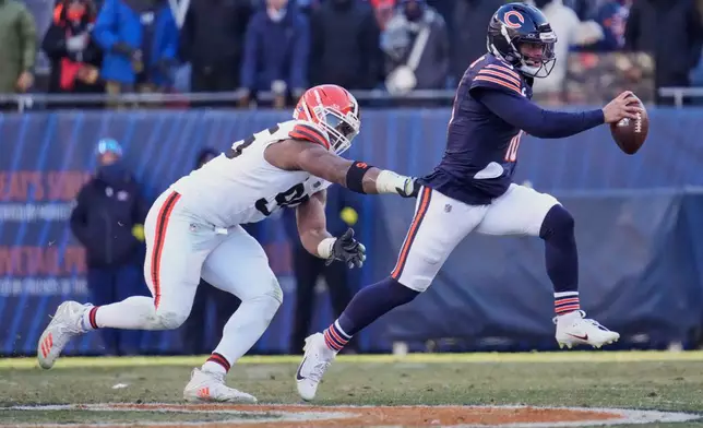 Chicago Bears quarterback Caleb Williams, right, avoids a tackle by Cleveland Browns defensive end Myles Garrett, left, in the second half of an NFL football game in Chicago, Sunday, Dec. 14, 2025. (AP Photo/Nam Y. Huh)