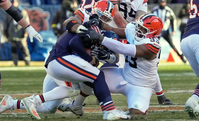 Cleveland Browns defensive end Myles Garrett, rear, and defensive tackle Shelby Harris (93), right, sack Chicago Bears quarterback Caleb Williams in the second half of an NFL football game in Chicago, Sunday, Dec. 14, 2025. (AP Photo/Nam Y. Huh)