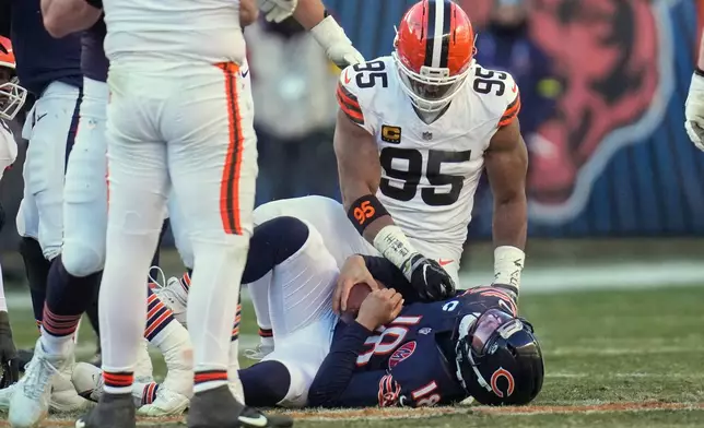 Cleveland Browns defensive end Myles Garrett (95) and Chicago Bears quarterback Caleb Williams (18) after a sack in the second half of an NFL football game in Chicago, Sunday, Dec. 14, 2025. (AP Photo/Erin Hooley)