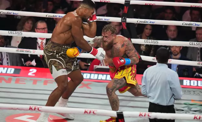 Jake Paul, right, and Anthony Joshua compete in their heavyweight boxing match, Friday, Dec. 19, 2025, in Miami, Fla. (AP Photo/Lynne Sladky)
