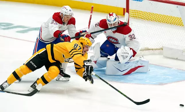 Pittsburgh Penguins' Sidney Crosby (87) reaches for the puck during the first period of an NHL hockey game against the Montréal Canadiens, Thursday, Dec. 11, 2025, in Pittsburgh. (Matt Freed/Pittsburgh Post-Gazette via AP)