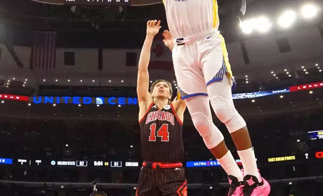 Chicago Bulls forward Matas Buzelis (14) defends against Golden State Warriors forward Jimmy Butler III (10) during the second half of an NBA basketball game Sunday, Dec. 7, 2025, in Chicago. (AP Photo/David Banks)