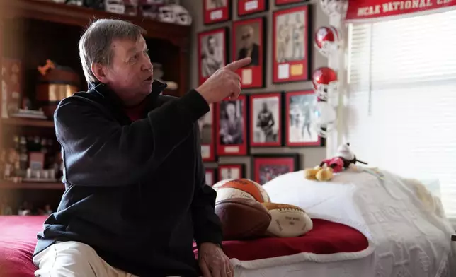 Bill Murphy points to a wall of framed sports photos in a room at his home in Greenfield, Ind., Wednesday, Dec. 17, 2025. (AP Photo/Obed Lamy)