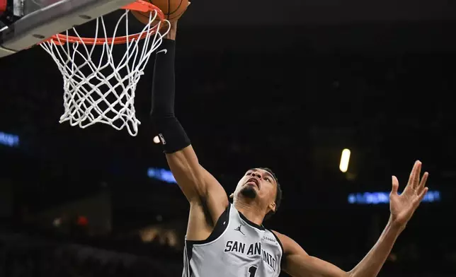 San Antonio Spurs forward Victor Wembanyama (1) dunks against the Washington Wizards during the second half of an NBA basketball game in San Antonio, Thursday, Dec. 18, 2025. (AP Photo/Billy Calzada)