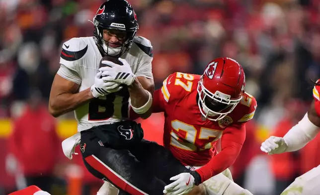 Houston Texans wide receiver Jayden Higgins (81) catches a pass for a first down as Kansas City Chiefs defensive back Chamarri Conner (27) defends during the second half of an NFL football game Sunday, Dec. 7, 2025, in Kansas City, Mo. (AP Photo/Charlie Riedel)