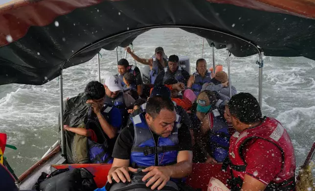 Luis Sanchez, center, rides on a boat with other Venezuelan migrants after giving up hope of reaching the U.S. amid Trump's crackdown on migration, Feb. 23, 2025, near Gardi Sugdub, along Panama's Caribbean coast. (AP Photo/Matias Delacroix, File)