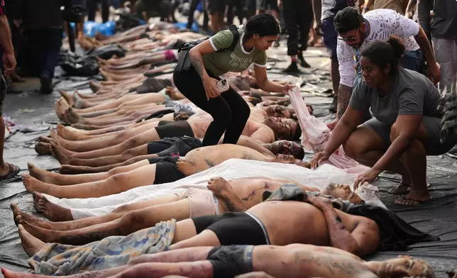 EDS NOTE: GRAPHIC CONTENT - Relatives look at the bodies of people killed the day before during a police raid targeting the Comando Vermelho gang in the Complexo da Penha favela of Rio de Janeiro, Brazil, Oct. 29, 2025. (AP Photo/Silvia Izquierdo, File)