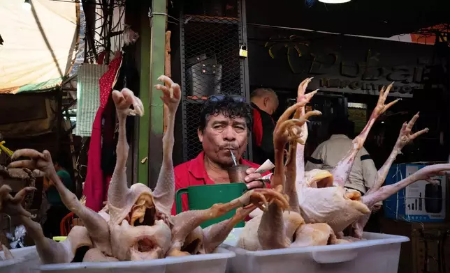 Chicken vendor Silvino sips on "terere", an infusion of cold yerba mate as he waits for customers at Market No. 4 in Asuncion, Paraguay, July 5, 2025. (AP Photo/Jorge Saenz, File)