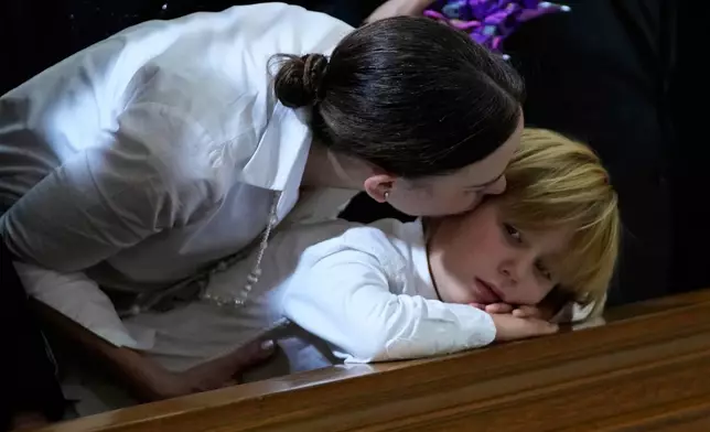 Maria Claudia Tarazona kisses her son Alejandro during the funeral service for her husband, presidential hopeful and opposition Sen. Miguel Uribe, who died from wounds suffered when he was shot at a political rally, in Bogota, Colombia, Aug. 13, 2025. (AP Photo/Fernando Vergara, File)