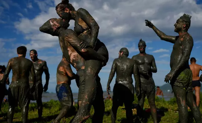 Revelers share a kiss during the traditional Mud Block carnival party in Paraty, Brazil, March 1, 2025. (AP Photo/Andre Penner, File)