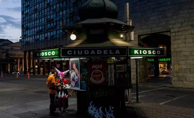 A person in costume buys a snack at a small store ahead of carnival celebrations in downtown Montevideo, Uruguay, Jan. 23, 2025. (AP Photo/Matilde Campodonico, File)