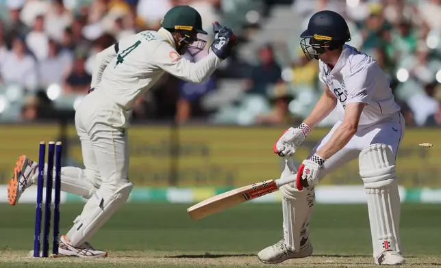 England's Zak Crawley reacts after he was out stumped by Australia's Alex Carey, left, during play on day four of the third Ashes cricket test between England and Australia in Adelaide, Australia, Saturday, Dec. 20, 2025. (AP Photo/James Elsby)