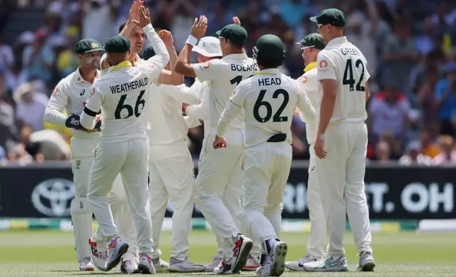 Australia's Pat Cummins is congratulated by teammates after dismissing England's Ben Duckettduring play on day four of the third Ashes cricket test between England and Australia in Adelaide, Australia, Saturday, Dec. 20, 2025. (AP Photo/James Elsby)