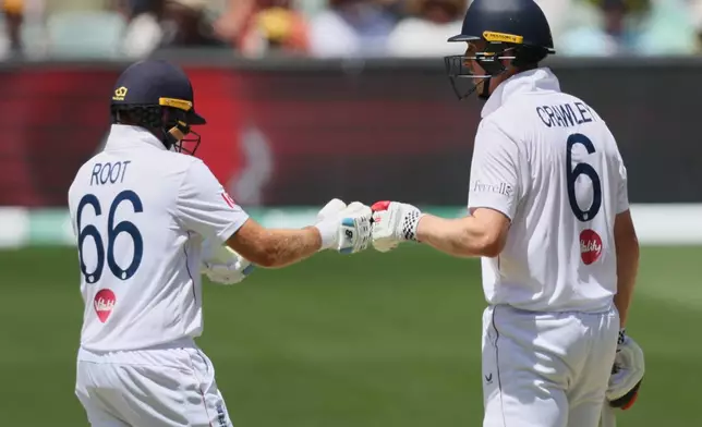 England batsmen Zak Crawley, right, and Joe Root gesture during play on day four of the third Ashes cricket test between England and Australia in Adelaide, Australia, Saturday, Dec. 20, 2025. (AP Photo/James Elsby)