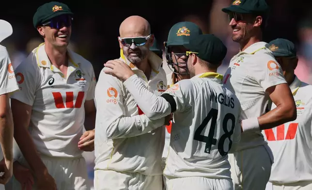 Australia's Nathan Lyon, second left, is congratulated by teammates after dismissing England's Ben Stokes during play on day four of the third Ashes cricket test between England and Australia in Adelaide, Australia, Saturday, Dec. 20, 2025. (AP Photo/James Elsby)