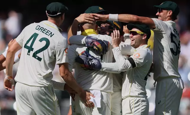 Australia's Nathan Lyon, second left, is congratulated by teammates after dismissing England's Ben Stokes during play on day four of the third Ashes cricket test between England and Australia in Adelaide, Australia, Saturday, Dec. 20, 2025. (AP Photo/James Elsby)