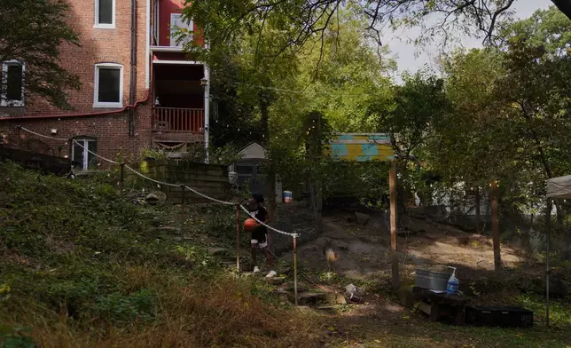 A boy prepares to throw a basketball up the hill to his friends while at the Baltimore Gift Economy's third annual "Finding Home" gathering on Collins Avenue in Baltimore on Sunday, Oct. 19, 2025. (AP Photo/Jessie Wardarski)