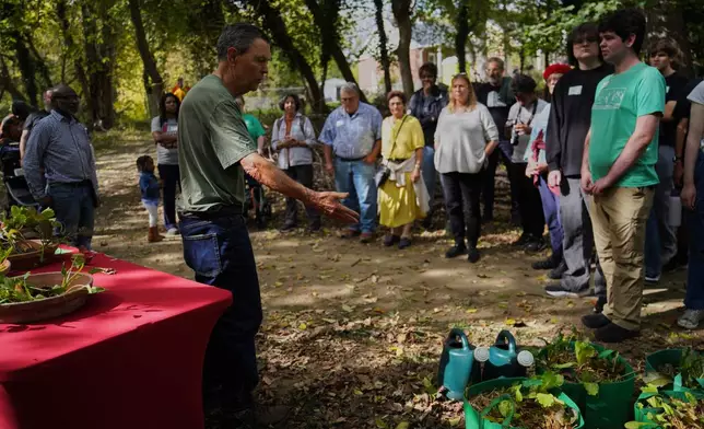 Visitors learn about fall crops like lettuce and kale while on a walking tour of Collins Avenue during the Baltimore Gift Economy's third annual "Finding Home" gathering, Sunday, Oct. 19, 2025, in Baltimore. (AP Photo/Jessie Wardarski)