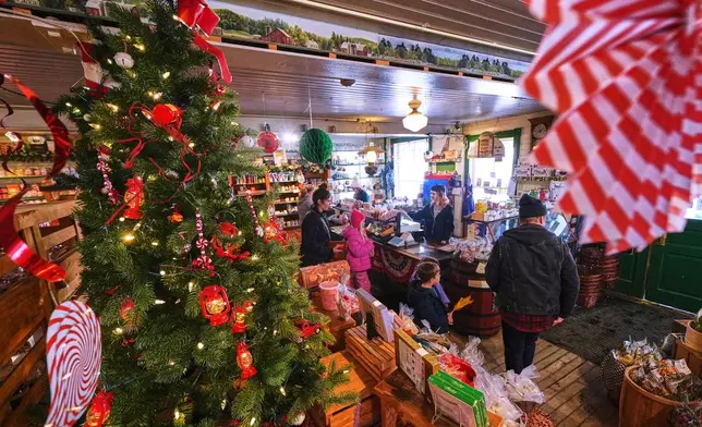 Post-holiday shoppers pass a Christmas tree at Calef's Country Store, Friday, Dec. 26, 2025, in Barrington, N.H. (AP Photo/Charles Krupa)