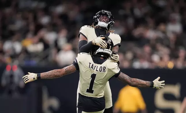 New Orleans Saints cornerback Alontae Taylor (1) celebrates with cornerback Quincy Riley (29) after a sack during the second half of an NFL football game against the New York Jets, Sunday, Dec. 21, 2025, in New Orleans. (AP Photo/Gerald Herbert)