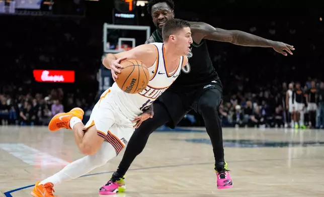 Phoenix Suns guard Collin Gillespie, front, works toward the basket as Minnesota Timberwolves forward Julius Randle defends during the second half of an NBA basketball game, Monday, Dec. 8, 2025, in Minneapolis. (AP Photo/Abbie Parr)
