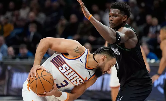 Phoenix Suns forward Dillon Brooks (3) handles the ball as Minnesota Timberwolves guard Anthony Edwards defends during the second half of an NBA basketball game, Monday, Dec. 8, 2025, in Minneapolis. (AP Photo/Abbie Parr)