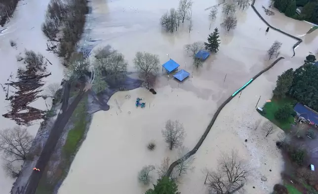 This image made from a video provided by the Pacific Police Department shows a road blocked off as it remains underwater, Tuesday, Dec. 16, 2025, in Pacific, Wash. (Pacific Police Department via AP)