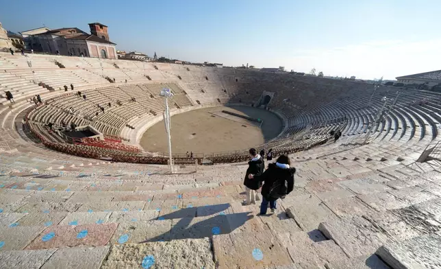 Visitors climb down at the Arena of Verona, Italy, Wednesday, Dec. 10, 2025. (AP Photo/Luca Bruno)