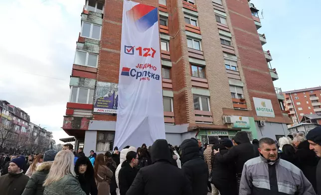 Supporters of Belgrade-backed Srpska Lista prepare to go at a polling station and cast their ballots in an early parliamentary election in the northern Serb-dominated part of ethnically divided town of Mitrovica, Kosovo, Sunday, Dec. 28, 2025. (AP Photo/Bojan Slavkovic)