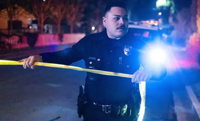A police officer blocks off a street near Rob Reiner's residence Sunday, Dec. 14, 2025, in the Brentwood section of Los Angeles. (AP Photo/Ethan Swope)