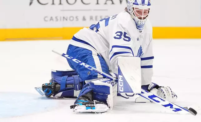 Toronto Maple Leafs goaltender Dennis Hildeby deflects the puck during the first period of an NHL hockey game against the Dallas Stars, Sunday, Dec. 21, 2025, in Dallas. (AP Photo/LM Otero)