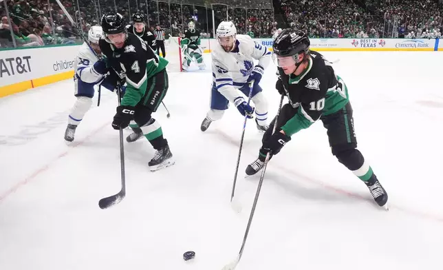 Dallas Stars center Oskar Bäck (10) and defenseman Miro Heiskanen (4) skate for the puck against Toronto Maple Leafs center Nicolas Roy (55) and right wing William Nylander (88) during the second period of an NHL hockey game Sunday, Dec. 21, 2025, in Dallas. (AP Photo/LM Otero)
