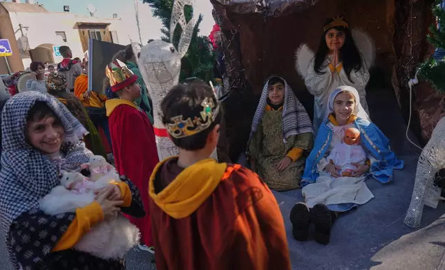 Wearing traditional costumes, children take part in the 40th annual Christmas parade heading towards the Basilica of the Annunciation in Nazareth, Israel, Wednesday, Dec. 24, 2025. (AP Photo/Ariel Schalit)