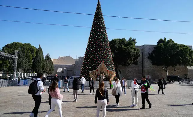 Palestinians and tourists visit the Manger Square and the Church of the Nativity, believed to be Jesus' birthplace, ahead of Christmas, in the West Bank city of Bethlehem, Tuesday, Dec. 23, 2025. (AP Photo/Nasser Nasser)