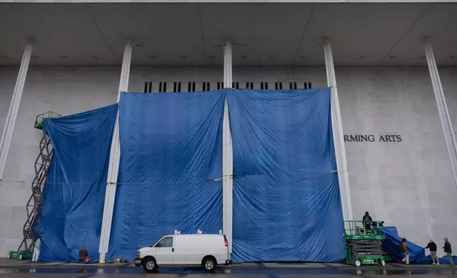 Tarps are installed in front of the sign on the Kennedy Center on Friday, Dec. 19, 2025, in Washington. (AP Photo/Mark Schiefelbein)