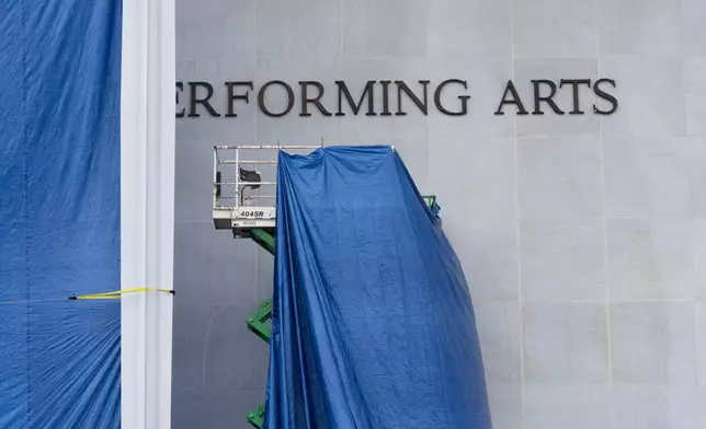 Tarps are installed in front of the sign on the Kennedy Center on Friday, Dec. 19, 2025, in Washington. (AP Photo/Mark Schiefelbein)