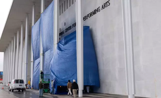 Tarps are installed in front of the sign on the Kennedy Center on Friday, Dec. 19, 2025, in Washington. (AP Photo/Mark Schiefelbein)