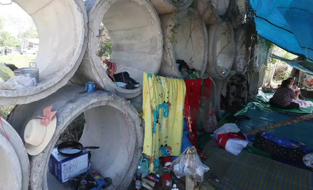Displaced people sit on the floor as they take their refuge in Prey Chamkar Ta Doak market in Banteay Meanchey province, Monday, Dec. 15, 2025, after fleeing home following fighting along the Thailand-Cambodia border. (AP Photo/Heng Sinith)