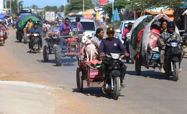 In this photo released by Agence Kampuchea Press (AKP), displaced people flee shortly after a Thai bombing near their villages, at Srei Snam district, Siem Reap province, Cambodia, Monday, Dec. 15, 2025.(AKP via AP)