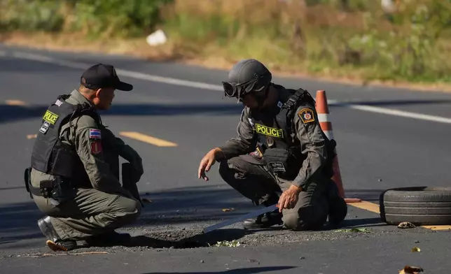 Members of a Thai Explosive Ordnance Disposal team inspect the site of a rocket attack during clashes between Thai and Cambodian soldiers in Kantharalak district of Sisaket province, Thailand, Monday, Dec. 15, 2025. (AP Photo/Sakchai Lalit)