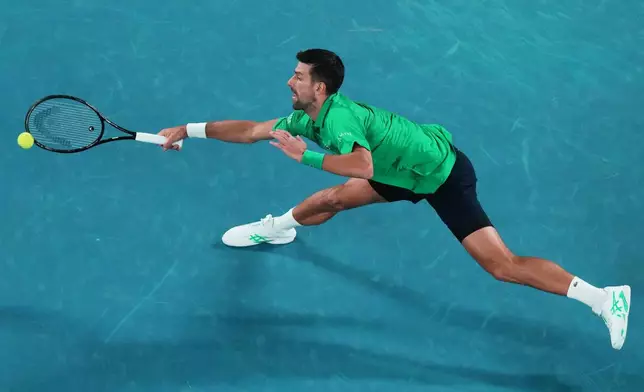Novak Djokovic of Serbia plays a forehand return to Pedro Martinez of Spain during their first round match at the Australian Open tennis championship in Melbourne, Australia, Monday, Jan. 19, 2026. (AP Photo/Aaron Favila)