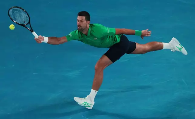 Novak Djokovic of Serbia plays a forehand return to Pedro Martinez of Spain during their first round match at the Australian Open tennis championship in Melbourne, Australia, Monday, Jan. 19, 2026. (AP Photo/Aaron Favila)