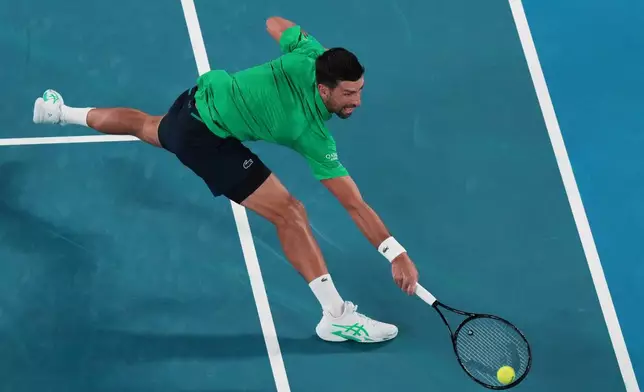 Novak Djokovic of Serbia plays a backhand return to Pedro Martinez of Spain during their first round match at the Australian Open tennis championship in Melbourne, Australia, Monday, Jan. 19, 2026. (AP Photo/Aaron Favila)