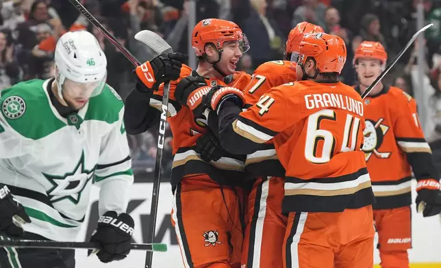 Anaheim Ducks right wing Beckett Sennecke, center, celebrates his goal with teammates during the third period of an NHL hockey game against the Dallas Stars Tuesday, Jan. 13, 2026, in Anaheim, Calif. (AP Photo/Gregory Bull)