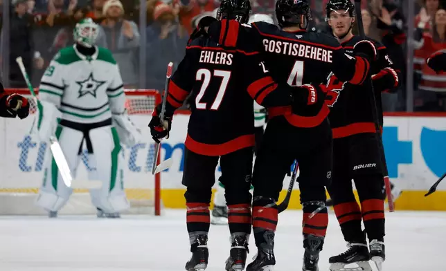 Carolina Hurricanes celebrate a goal by Shayne Gostisbehere (4) during the first period of an NHL hockey game against the Dallas Stars in Raleigh, N.C., Tuesday, Jan. 6, 2026. (AP Photo/Karl DeBlaker)