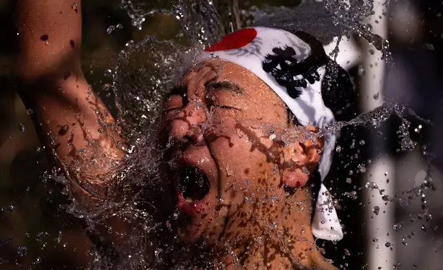A participant pours cold water over himself to purify his soul and pray for good health during a New Year's ritual at Kanda Myojin Shrine in Tokyo, Saturday, Jan. 17, 2026. (AP Photo/Louise Delmotte)